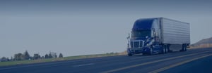 A semi truck driving on a road in the plains with a blue gradient overtop